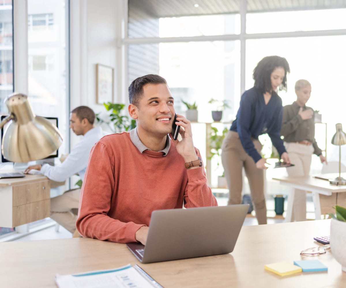 Man with laptop making a phone call
